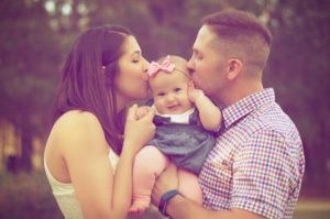 Parents kissing baby daughter